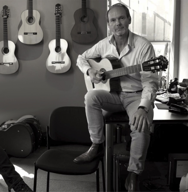 man in his office with guitars on the wall
